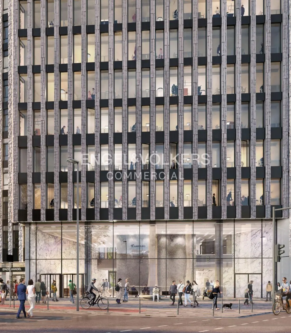 Modern office building with a grid-patterned stone facade, glass ground floor, and people walking on the sidewalk.