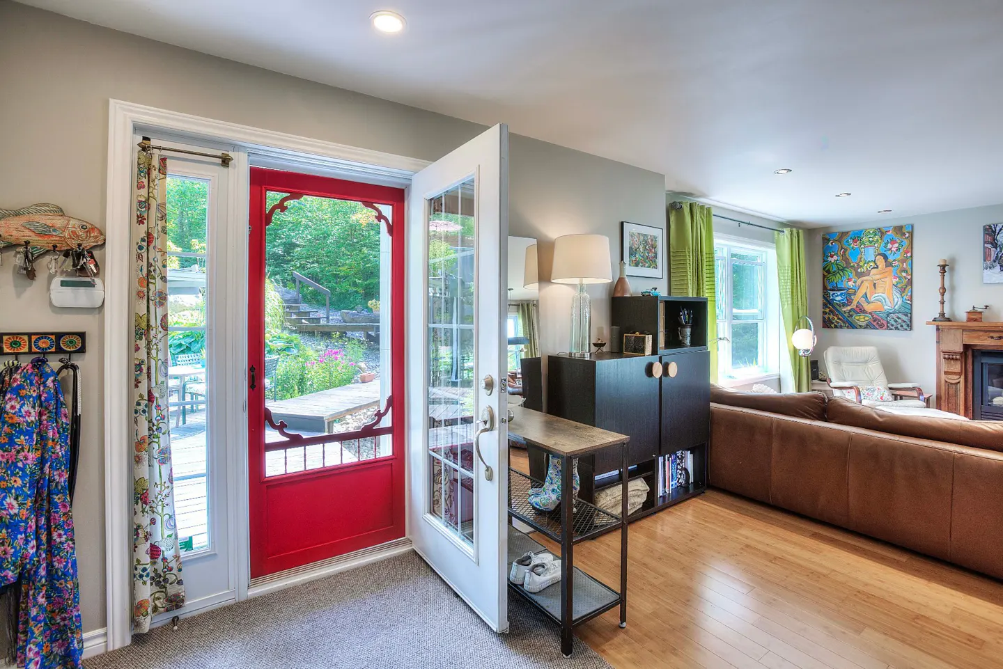 Entryway with open white door and red screen door leading to a garden. A coat rack and console table are visible.