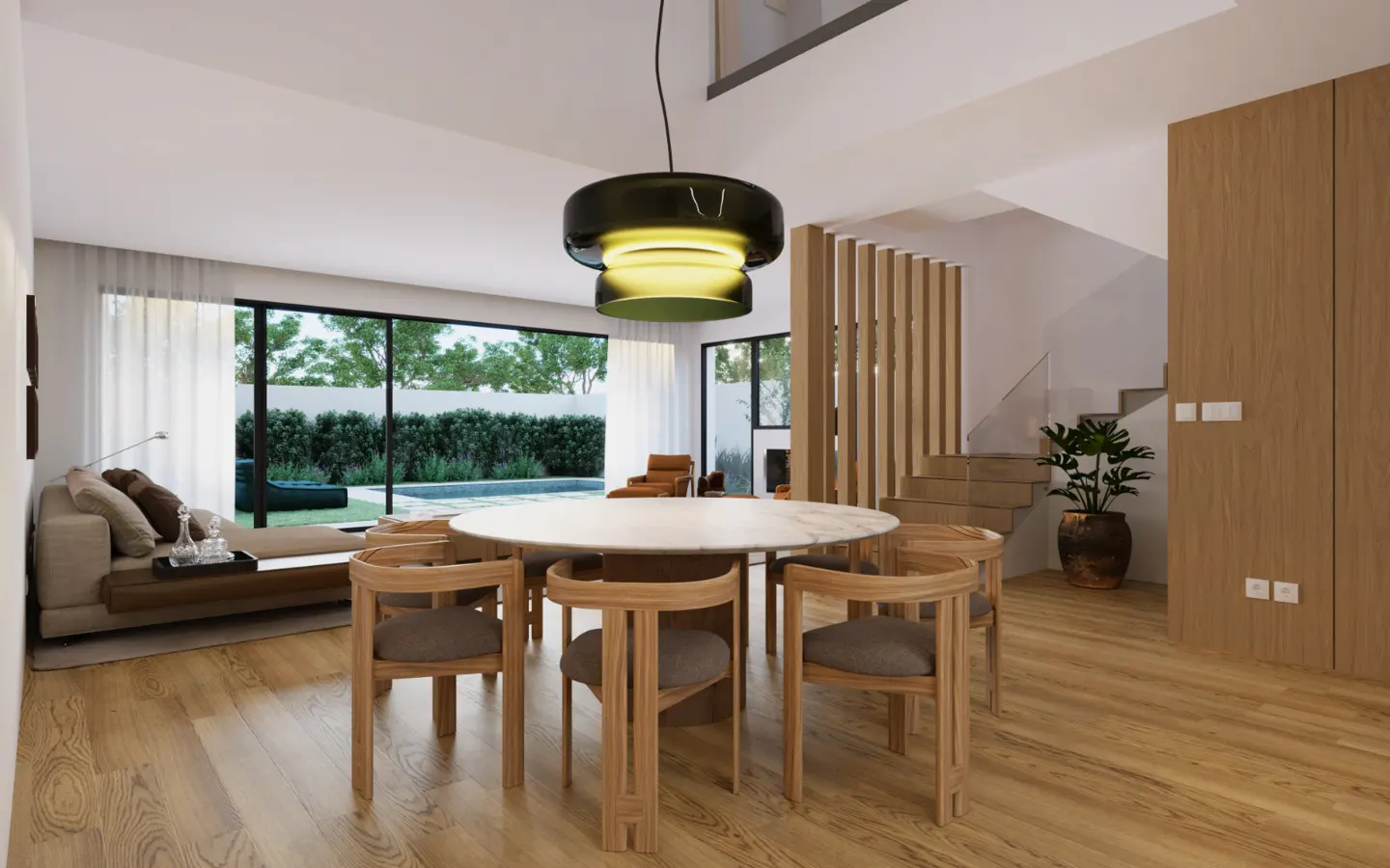 Bright, modern dining room with a round table, wooden chairs, and a unique pendant light. Large windows overlook a pool and garden. Stairs are visible.