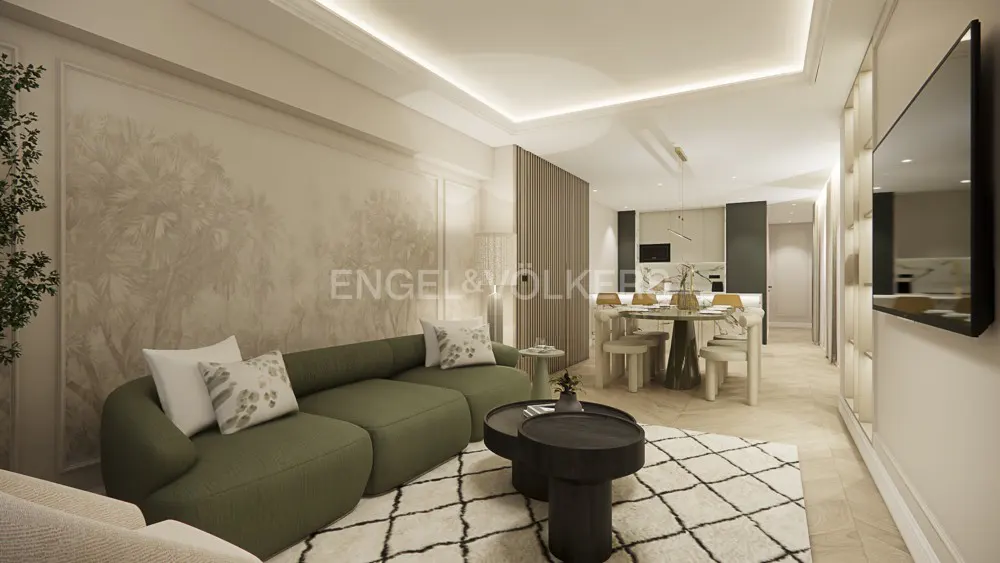 Modern living room with a green sofa, patterned rug, two black coffee tables, and a dining area in the background.