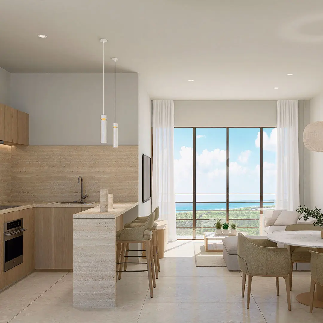 Open-concept living space with a kitchen, bar seating, and a living room with ocean views. Neutral color palette.