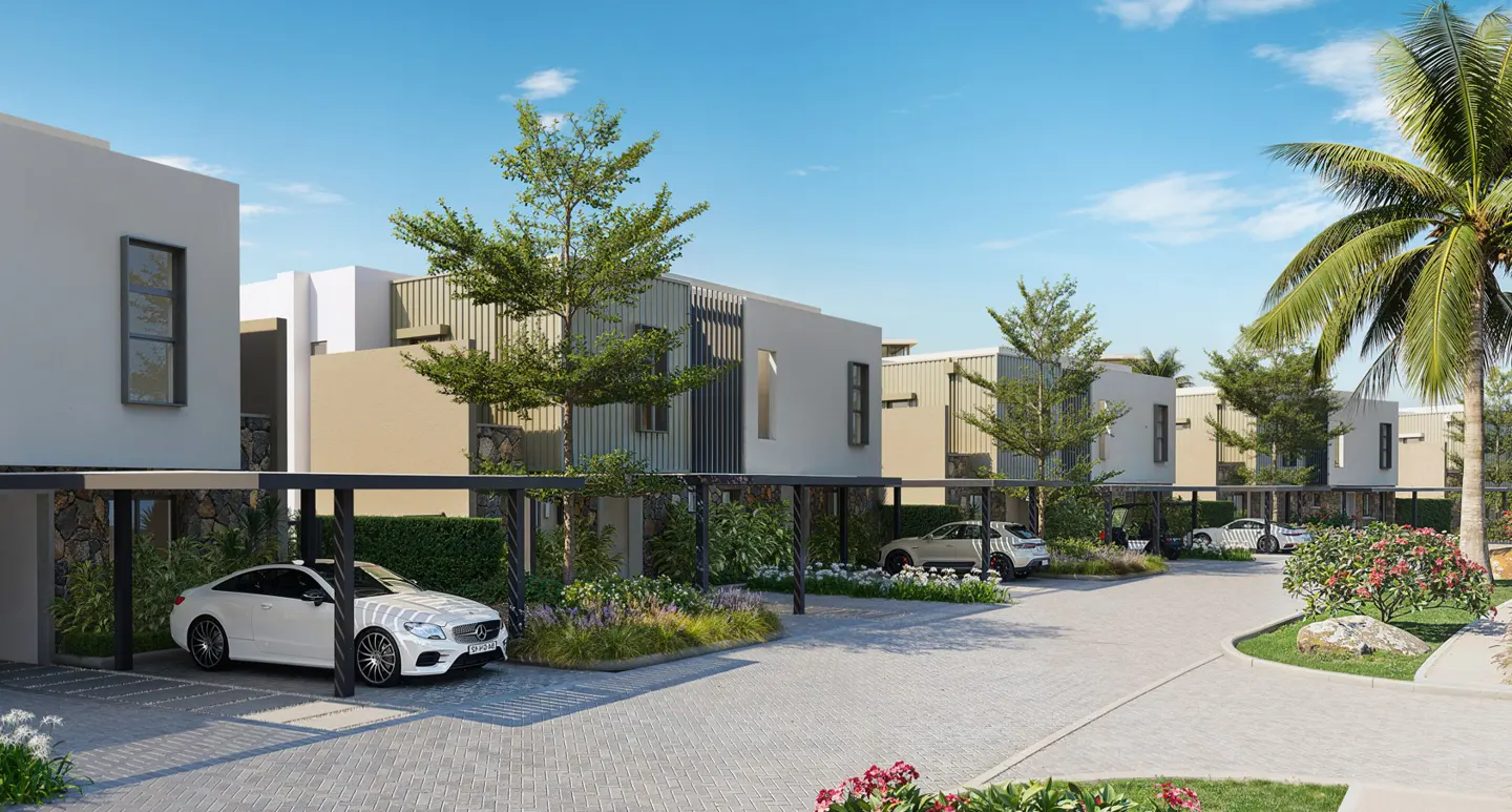 Modern townhouses with carports line a paved street under a blue sky. Cars are parked in the carports, and landscaping adds greenery.