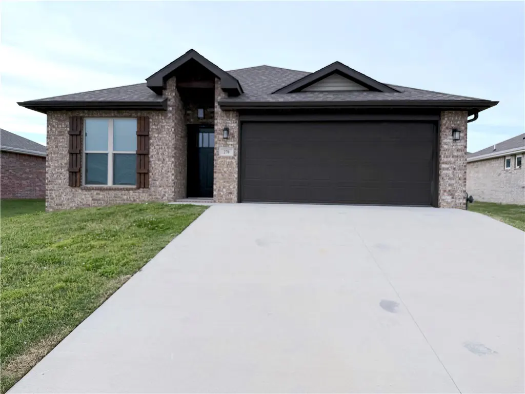 A single-story brick house with a dark brown garage door and a concrete driveway.