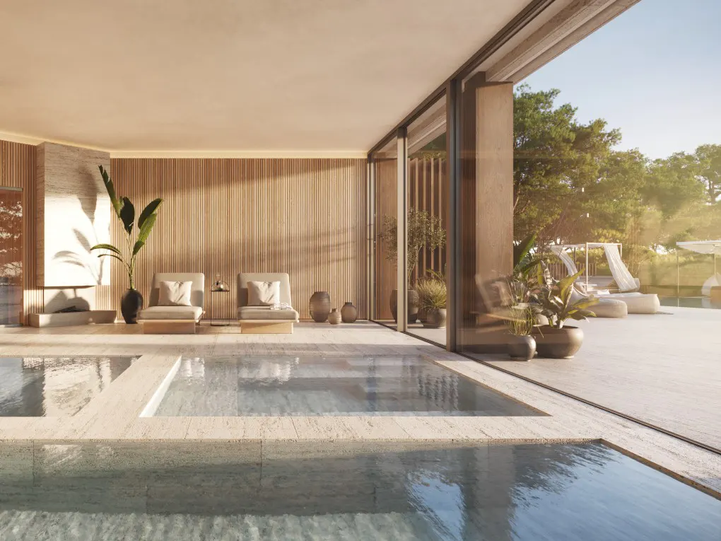 Indoor pool area with lounge chairs, wood paneling, and a large sliding glass door to an outdoor patio with cabanas.