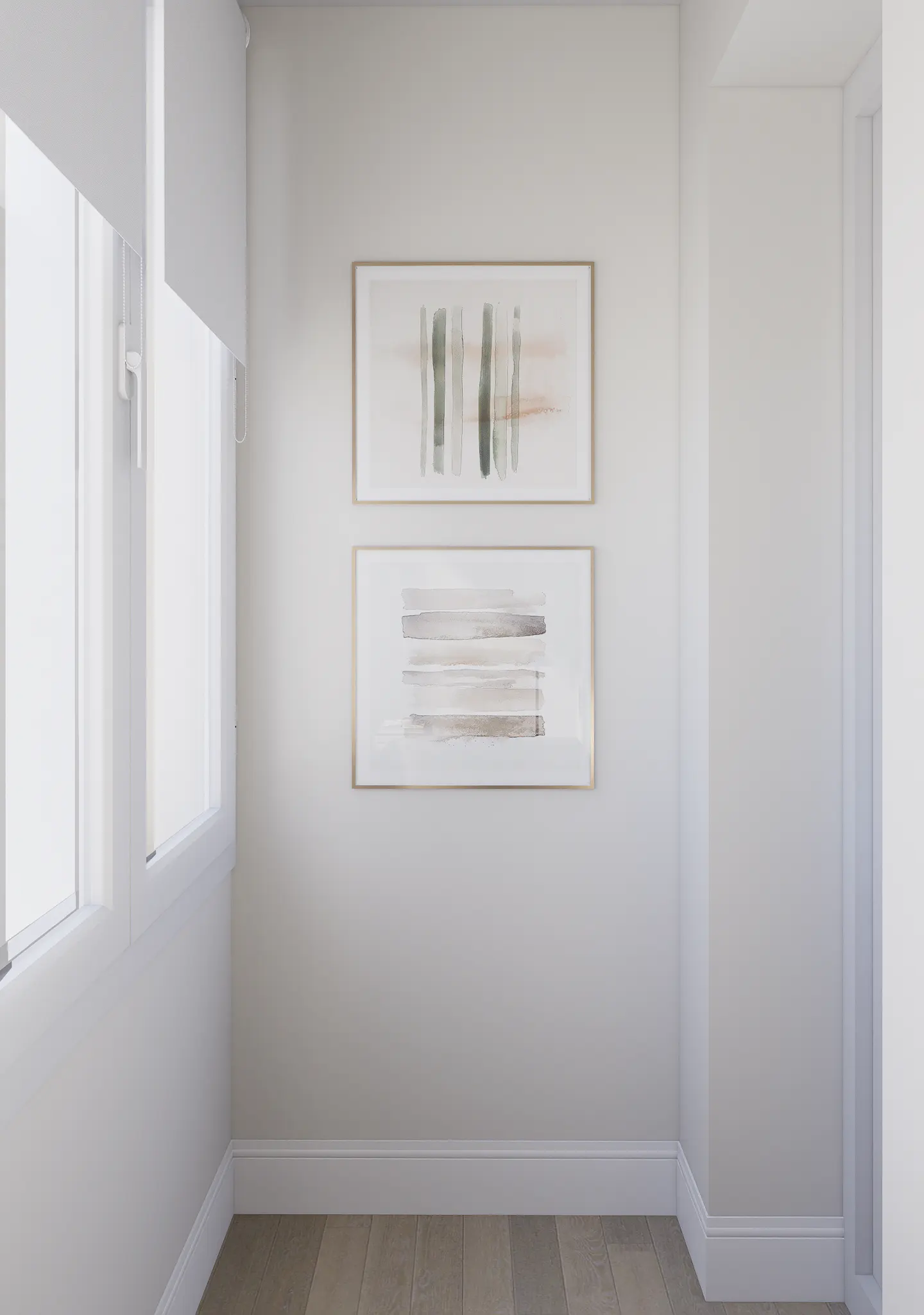 Two framed abstract watercolor paintings with neutral tones hang on a light gray wall next to a window.