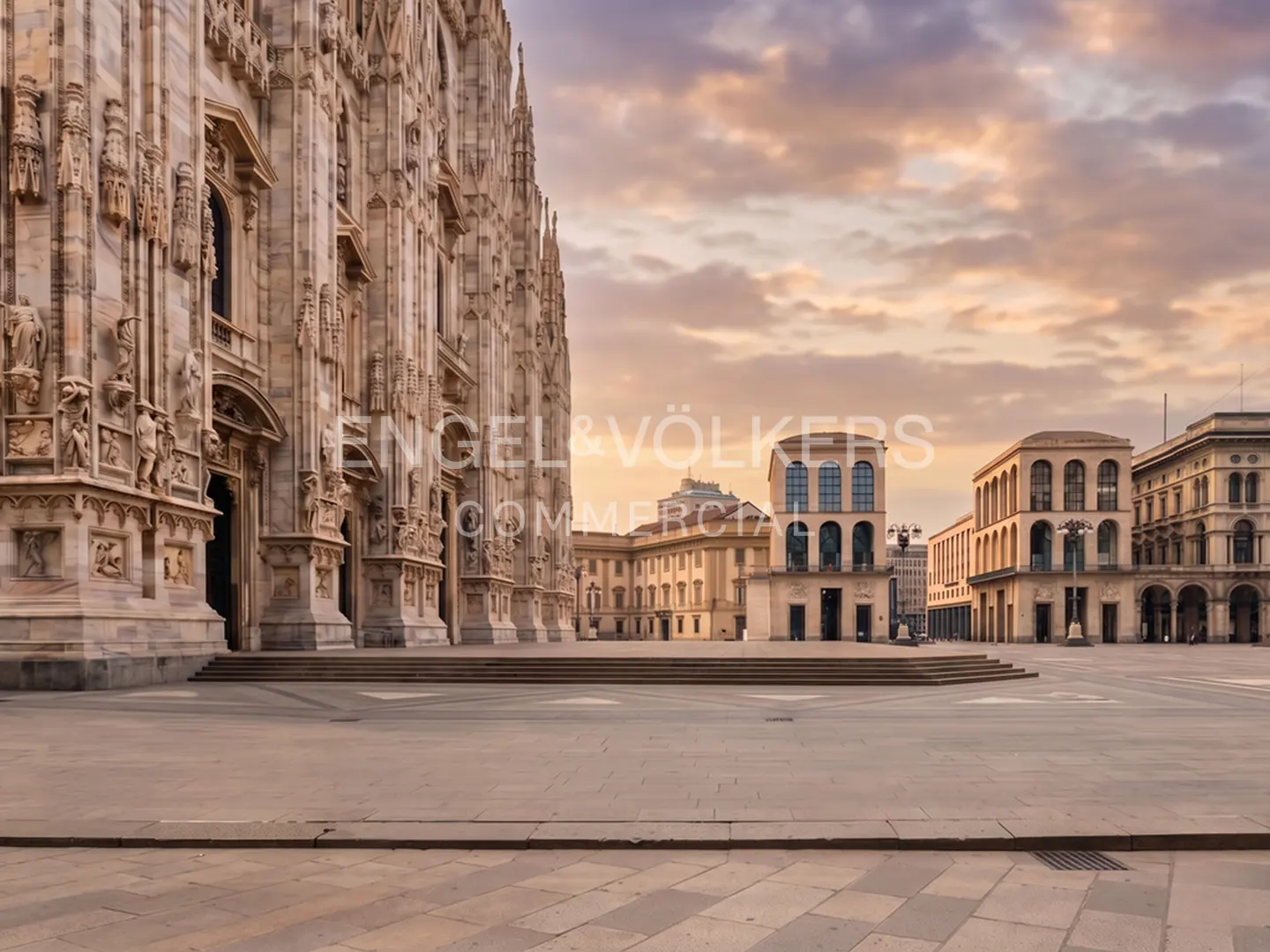 Milan Cathedral's ornate facade stands beside a large, empty plaza under a cloudy, sunset sky.