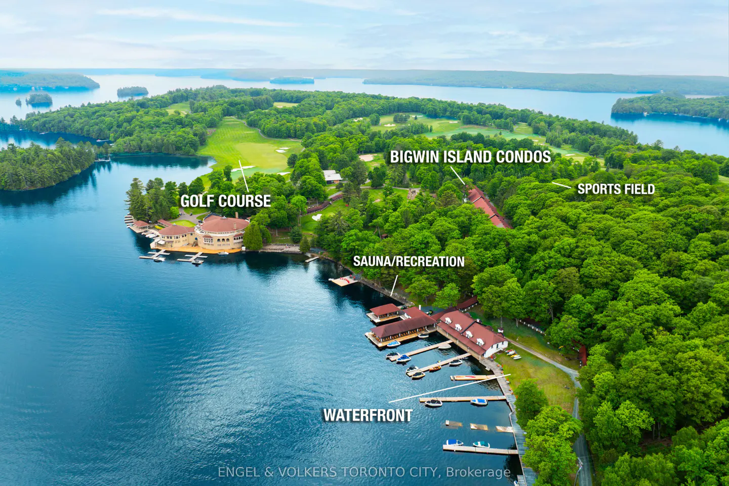 Aerial view of Bigwin Island condos, golf course, sports field, and waterfront on a lake.