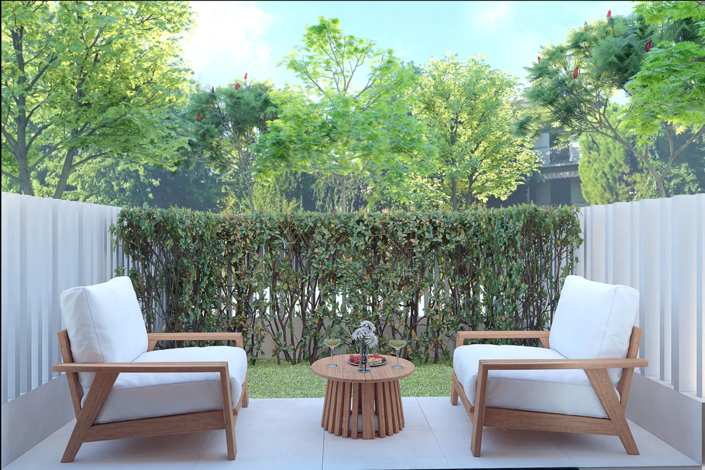 Outdoor patio with two white cushioned chairs, a round wooden table with drinks, and a green hedge backdrop.