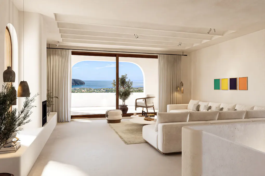 Bright living room with white walls, a large white sofa, and a view of the ocean through a large arched window.