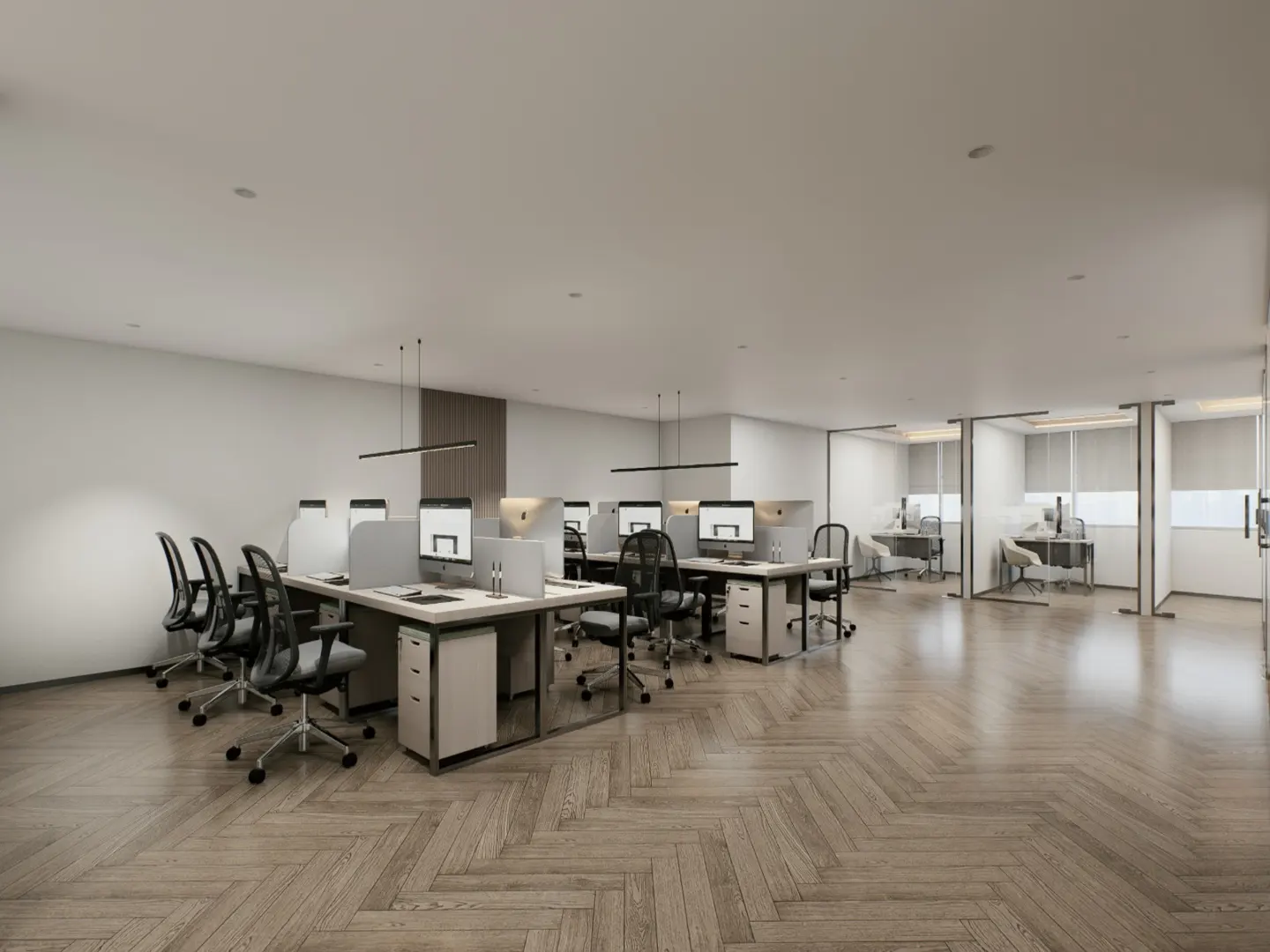 Bright, modern office space with desks, computers, and black chairs on a herringbone wood floor. Glass-walled offices in the background.