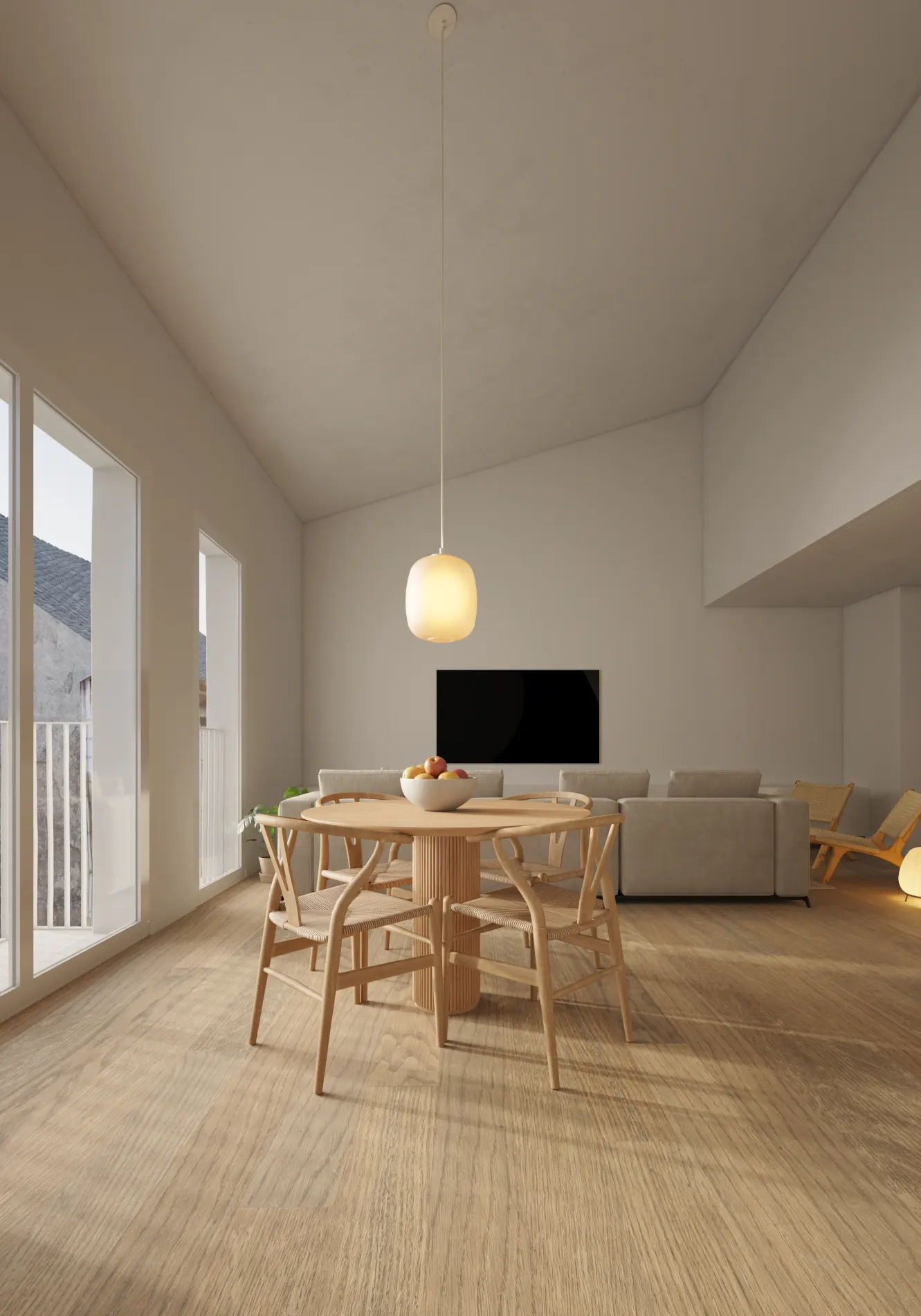 Modern dining area with a round wooden table, four chairs, and a glowing pendant light in a minimalist, open-plan room.