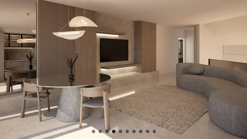 A modern living room with a round table, chairs, a gray sofa, and a TV on a wooden wall.