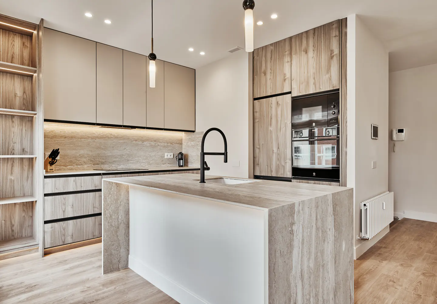 Modern kitchen with wood-grain cabinets, a stone island with a black faucet, and built-in appliances.