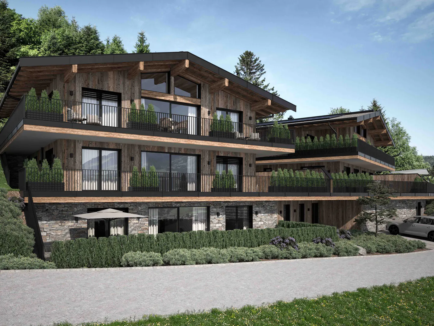 Exterior view of a modern, multi-story chalet with wood siding, black trim, and balconies with greenery. Stone base and manicured landscaping.