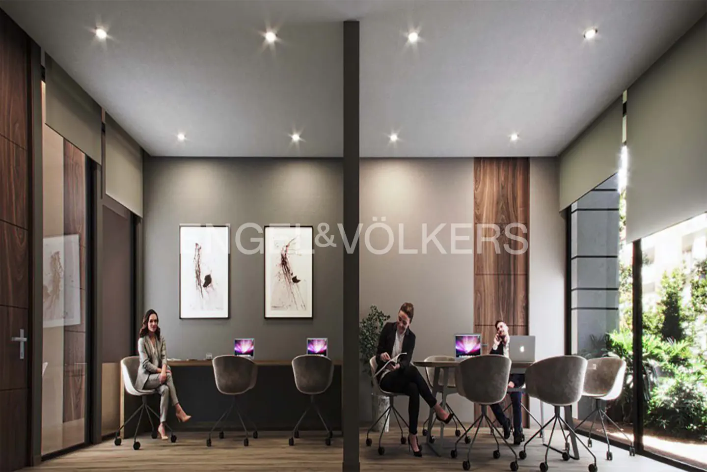 Real estate office interior with two women working at desks, and one woman sitting in a chair. Modern design with wood accents and artwork.