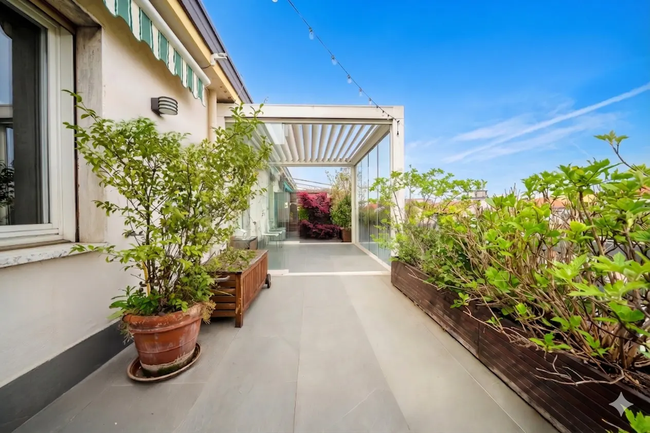 A rooftop terrace with potted plants, a pergola, and a view of the blue sky.