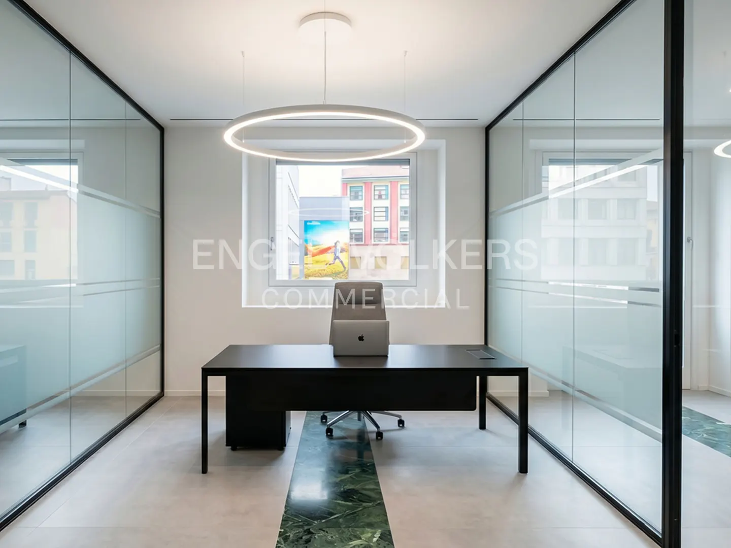 Office space with glass walls, a black desk, a laptop, and a circular light fixture. A green marble stripe runs through the floor.