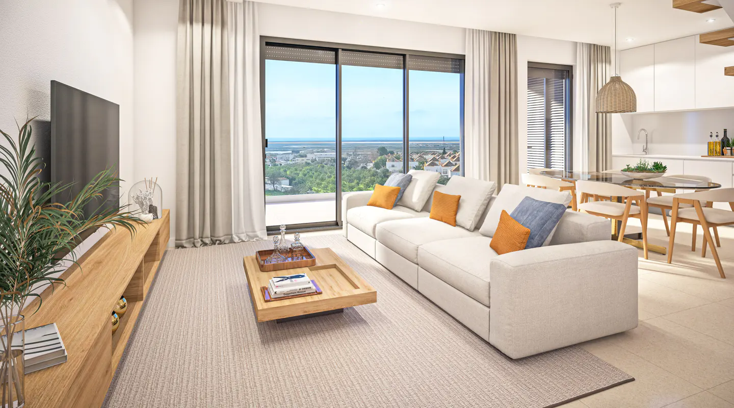 Bright living room with a white sofa, wood table, and large windows overlooking a cityscape. A TV and plant are on the left, and a dining area is visible in the background.