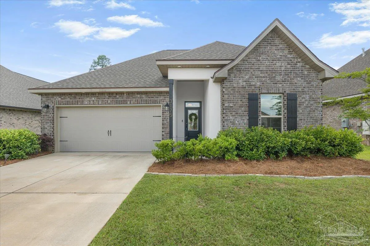 Exterior of a single-story brick house with a gray roof, a two-car garage, and a green lawn.