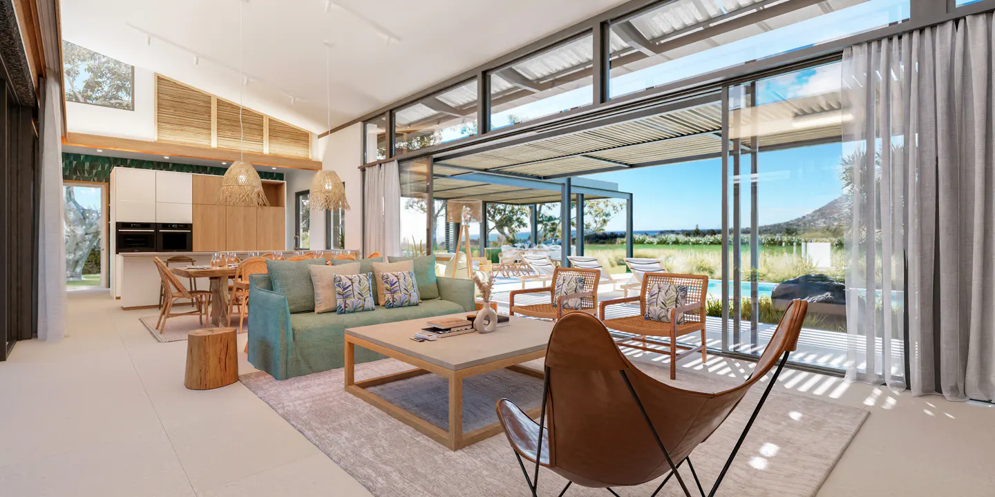 Bright, open living room with a teal sofa, rattan chairs, and a leather butterfly chair. Large windows offer a view of a pool and landscape.