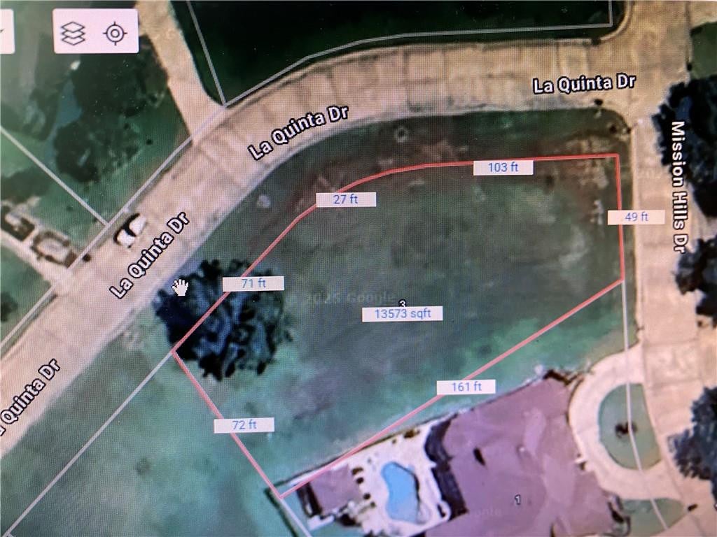 Aerial view of a 13,573 sqft vacant lot at the corner of La Quinta Dr and Mission Hills Dr with property dimensions outlined. [AI-generated text]