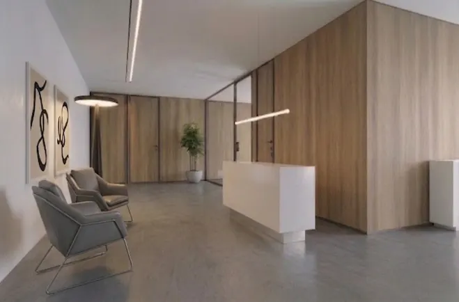 Modern office lobby with a white reception desk, two grey armchairs, wood-paneled walls, and abstract wall art.