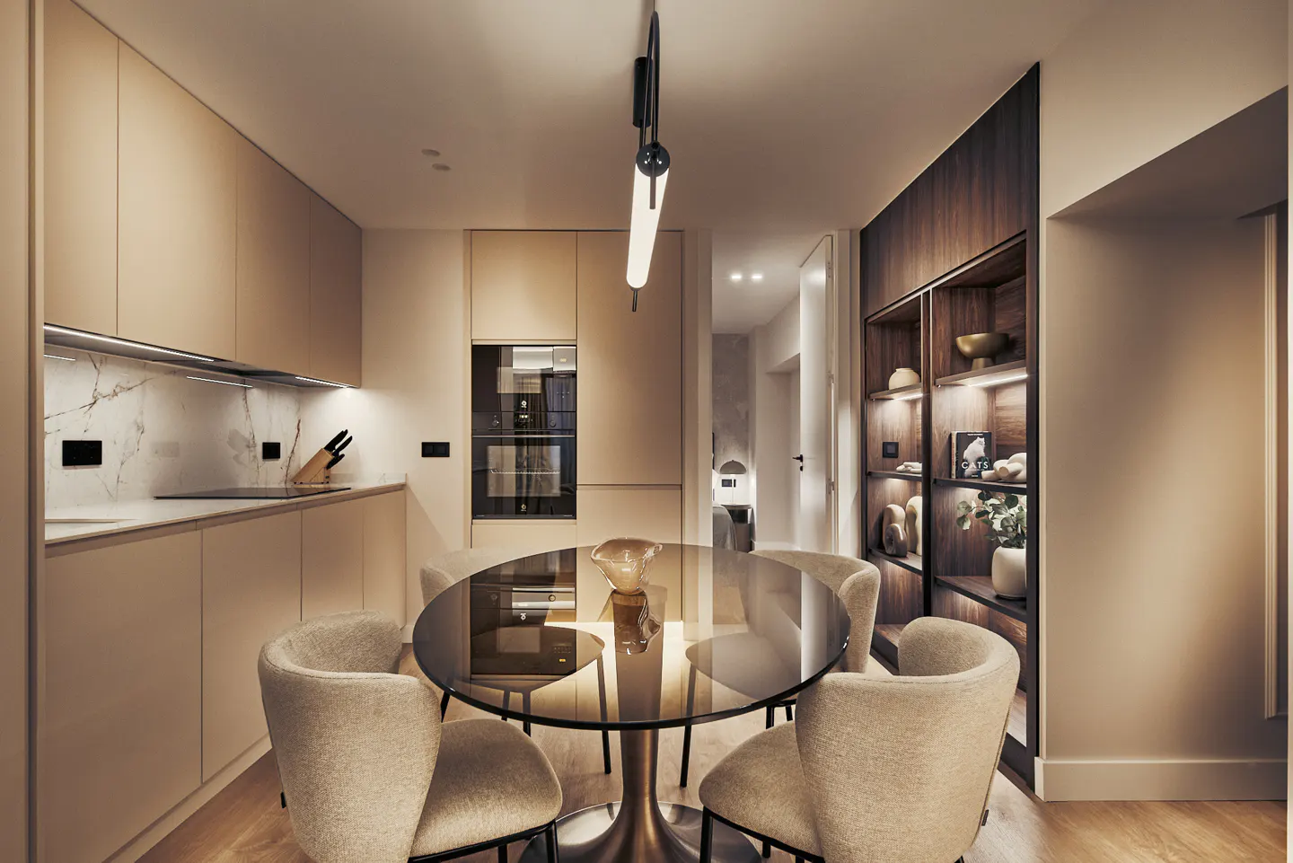 A modern kitchen with a round glass table, four beige chairs, and a sleek black and white pendant light. Built-in appliances and a dark wood shelving unit are visible.