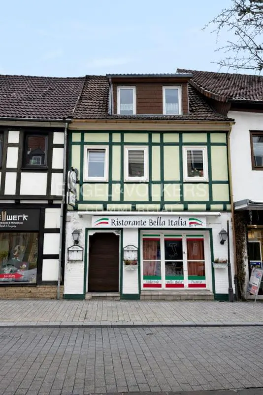 A two-story half-timbered building housing Ristorante Bella Italia, featuring a light green facade and dark brown door.