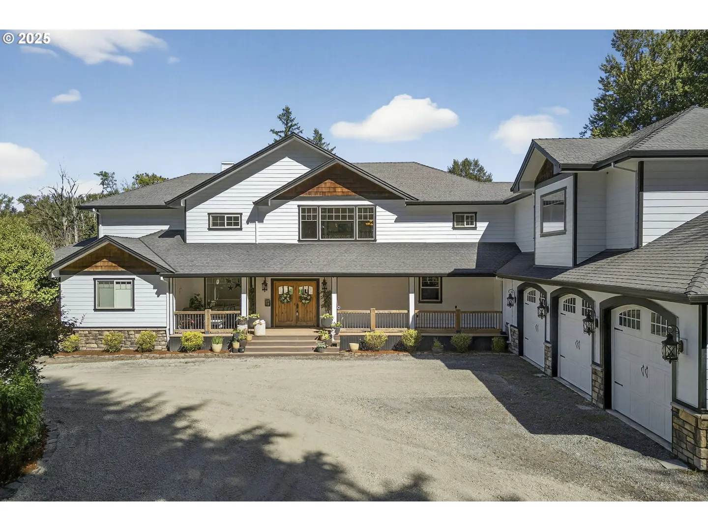 Two-story white house with a gray roof, a front porch, and a three-car garage.