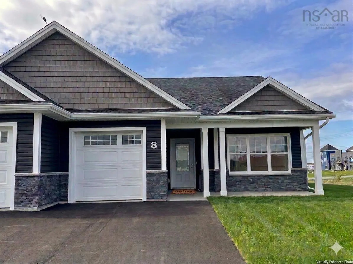 A single-story home with dark siding, a white garage door, and a gray front door. The house has a well-manicured lawn and a paved driveway.