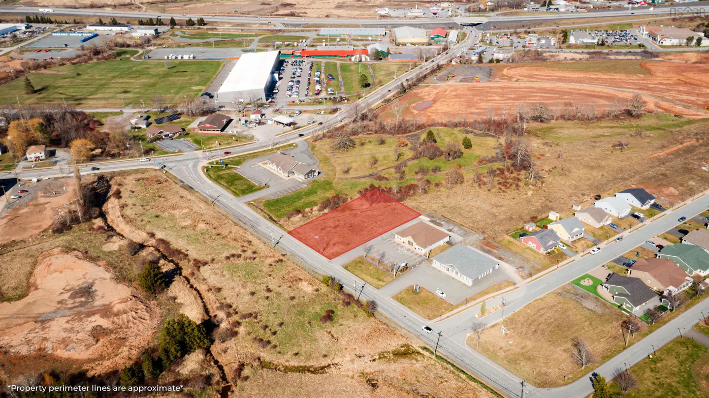 Aerial view of a vacant lot outlined in red, surrounded by roads, buildings, and residential areas.