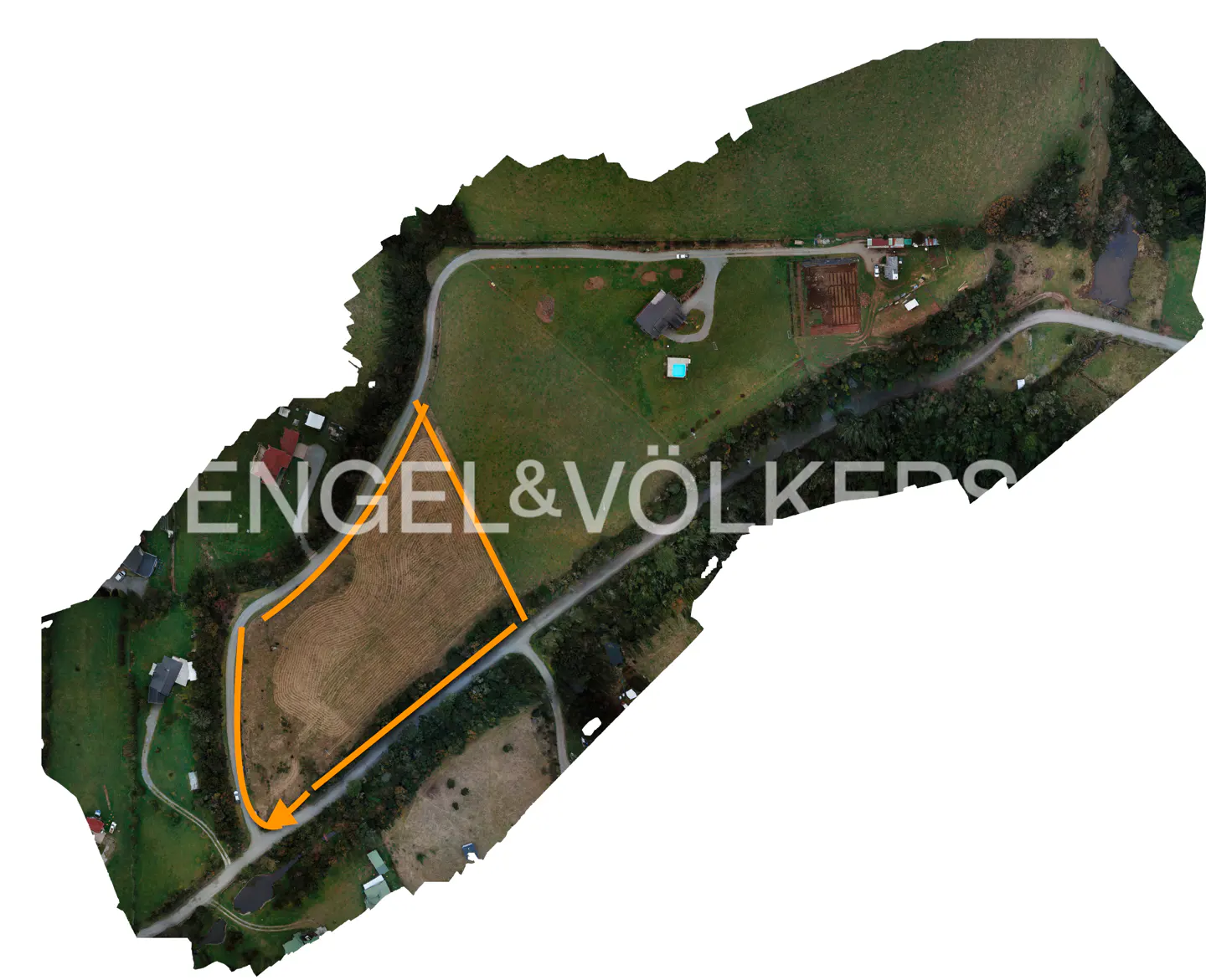 Aerial view of a property outlined in orange, surrounded by green fields, trees, and roads. The Engel & Völkers logo is superimposed.