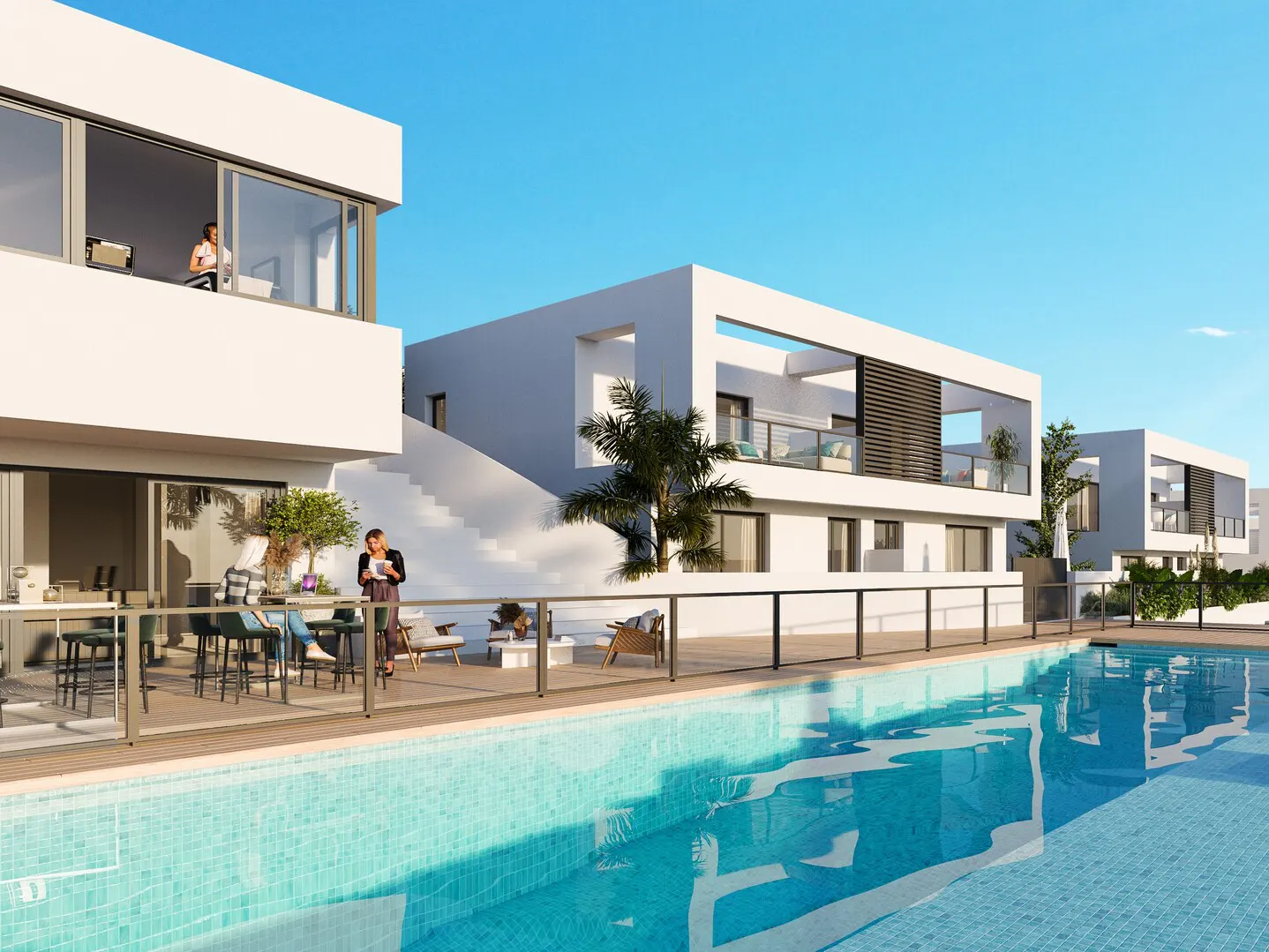 Modern white villas with a pool. People are on the patio and balcony. Blue sky.