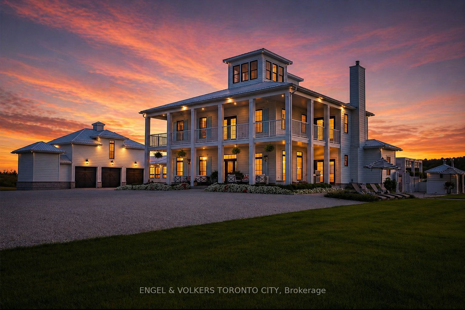 Two-story white house with a tower and a porch at sunset. A garage is on the left.