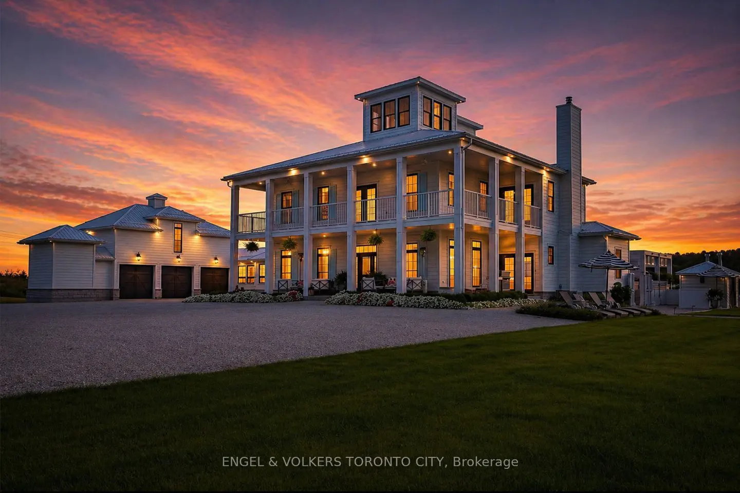 Two-story white house with a tower and a porch at sunset. A garage is on the left.