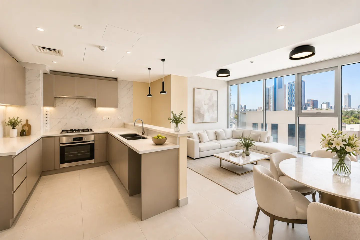 Open-concept apartment with a beige kitchen, white sofa, and round dining table with city views.