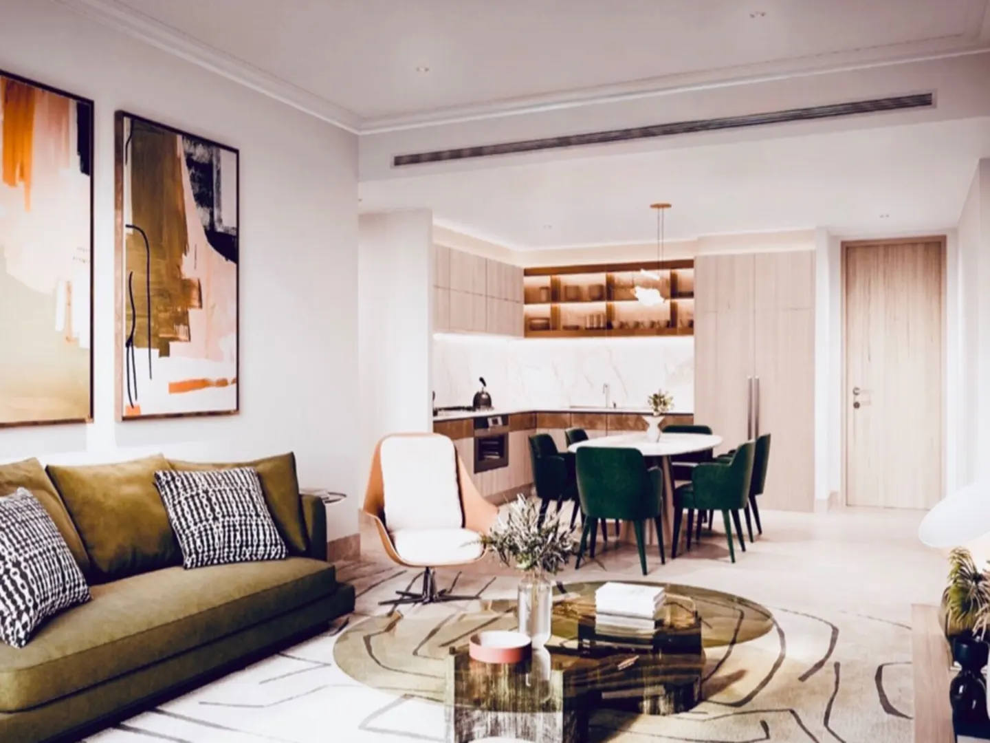 Open-concept living space with olive sofa, abstract art, and dining area with green chairs. Kitchen visible in the background.