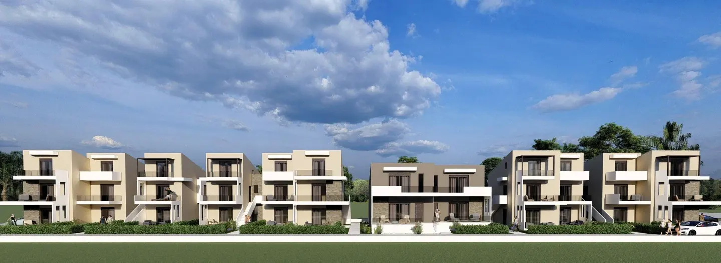 Row of modern, two-story townhouses with balconies, set against a blue sky with fluffy white clouds. A white car is parked in front.