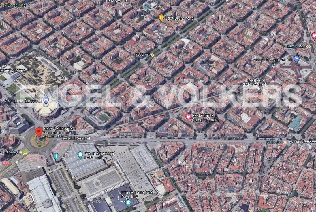 Aerial view of Barcelona, Spain, featuring the city's grid pattern, Plaza de España, and surrounding buildings.