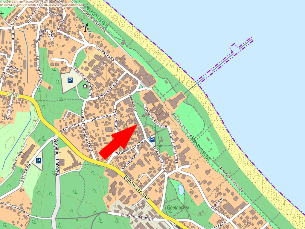 Map of a coastal town with streets, parks, and a pier, indicated by a red arrow.