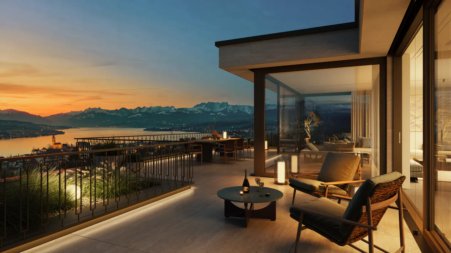 Luxury apartment balcony at sunset. Two chairs, table with wine, and mountain view.