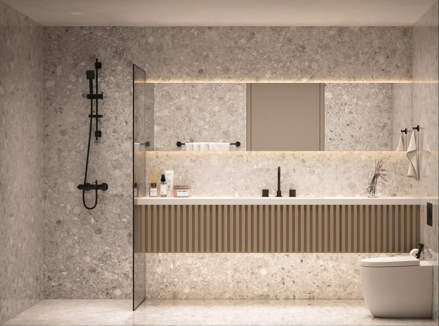 Modern bathroom with speckled gray tile, black fixtures, and a wood-paneled vanity. A large mirror with lighting sits above the sink.