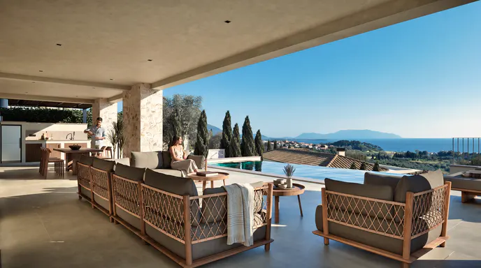 Covered patio with modern outdoor furniture, infinity pool, and panoramic ocean view with mountains in the distance.