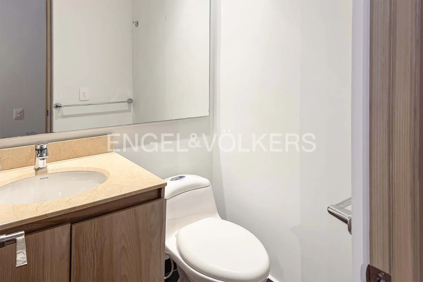 Small bathroom with a light wood vanity, beige stone countertop, white toilet, and a large wall mirror.