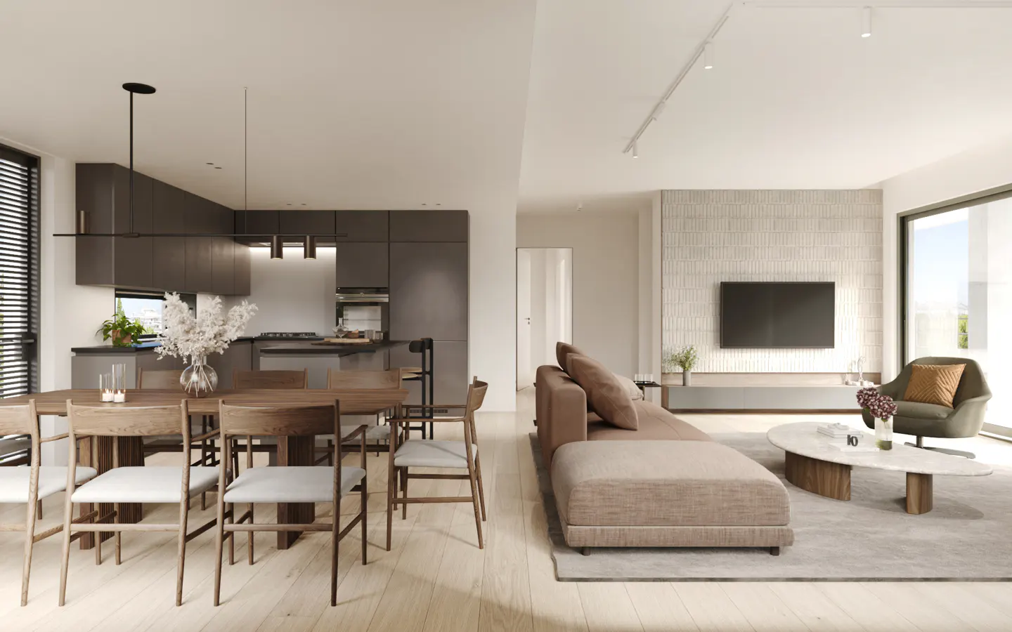 Open-concept living space with a dining table, brown sofa, and TV. The kitchen has gray cabinets and a breakfast bar. Light wood floors throughout.