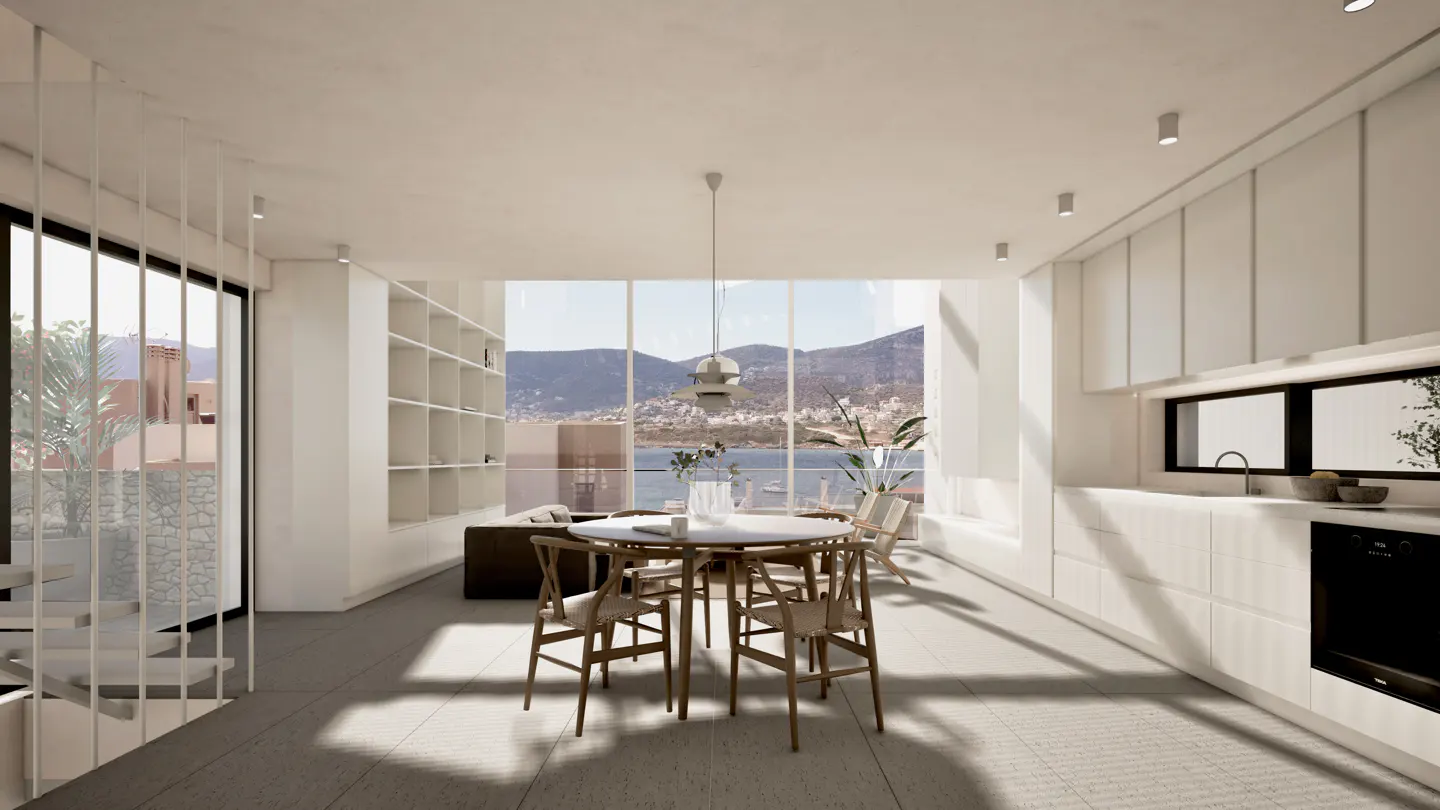 Modern open-plan kitchen and dining area with white cabinetry, a round table, and floor-to-ceiling views of the sea.