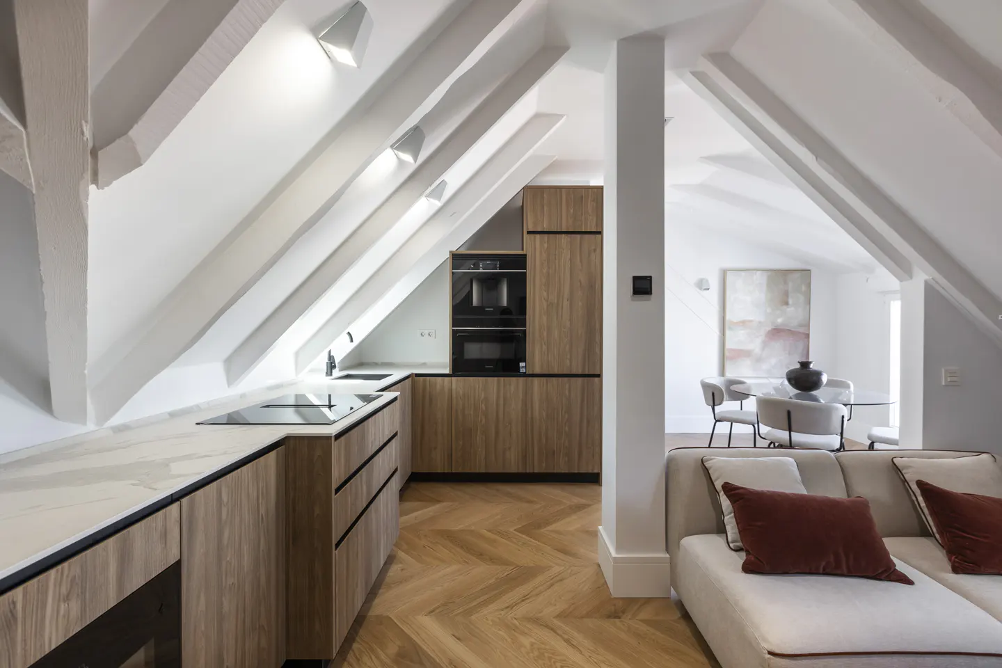 Open-concept living space with a kitchen, dining area, and living room. The kitchen has wood cabinets and white countertops.