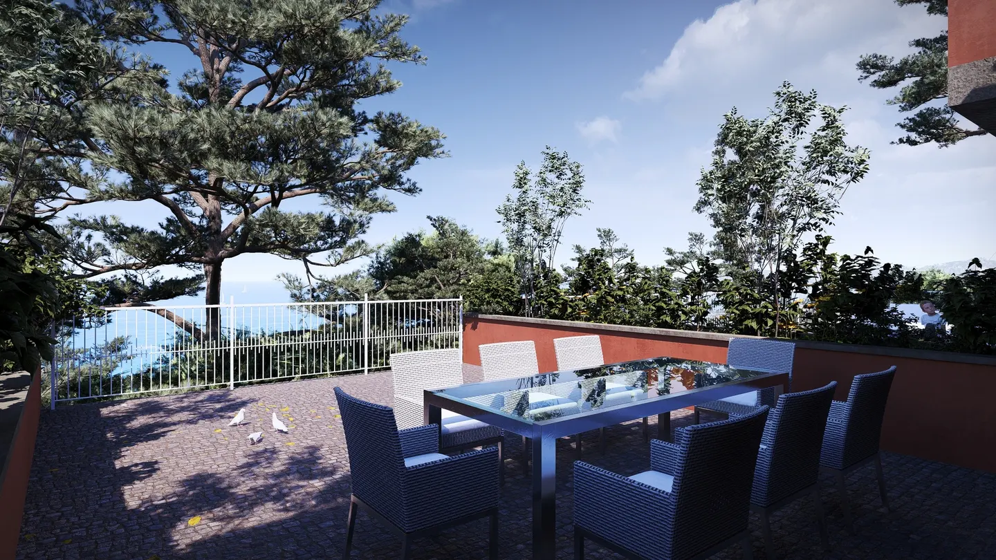 Outdoor patio with a glass table, wicker chairs, and ocean view. Trees and a white fence are in the background.