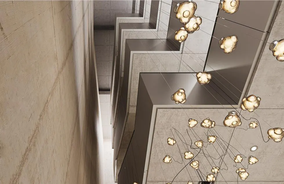 Modern staircase with concrete walls and steps, featuring a cloud-like chandelier with multiple lights hanging from the ceiling.