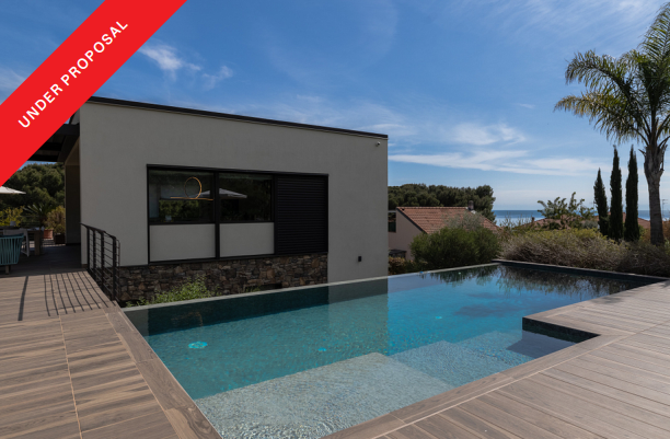 Modern villa surrounded by greenery, steps from the sea